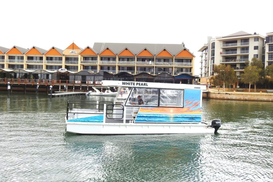 a small charter boat at Mandurah Ocean Marina in front of an apartment building