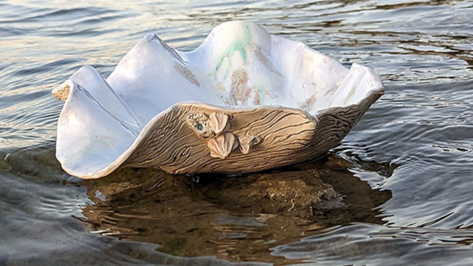 a shell sitting on the water in the middle of a body of water