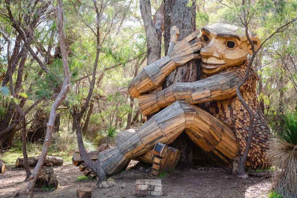 a wooden sculpture of a person hugging a tree in the woods