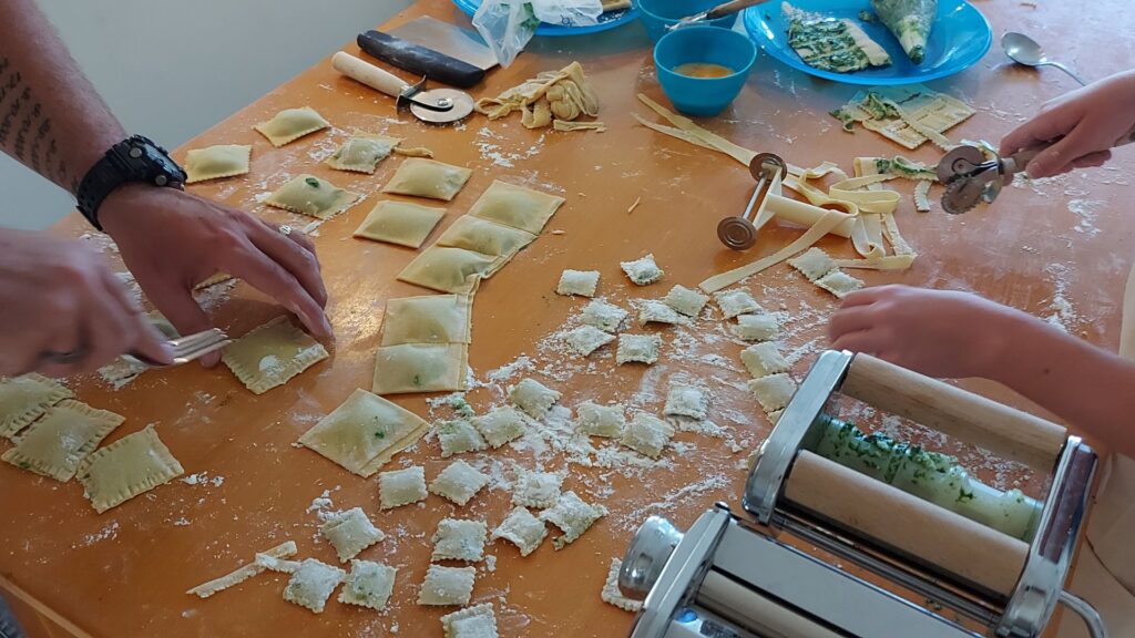a group of people making pasta on a table