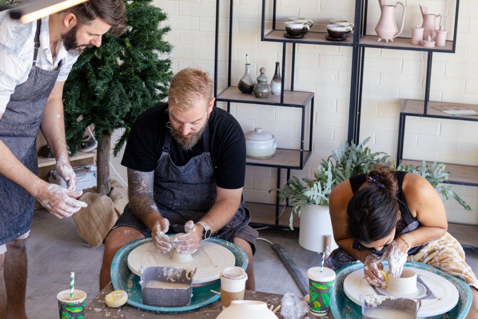 a group of people working on pottery in a studio