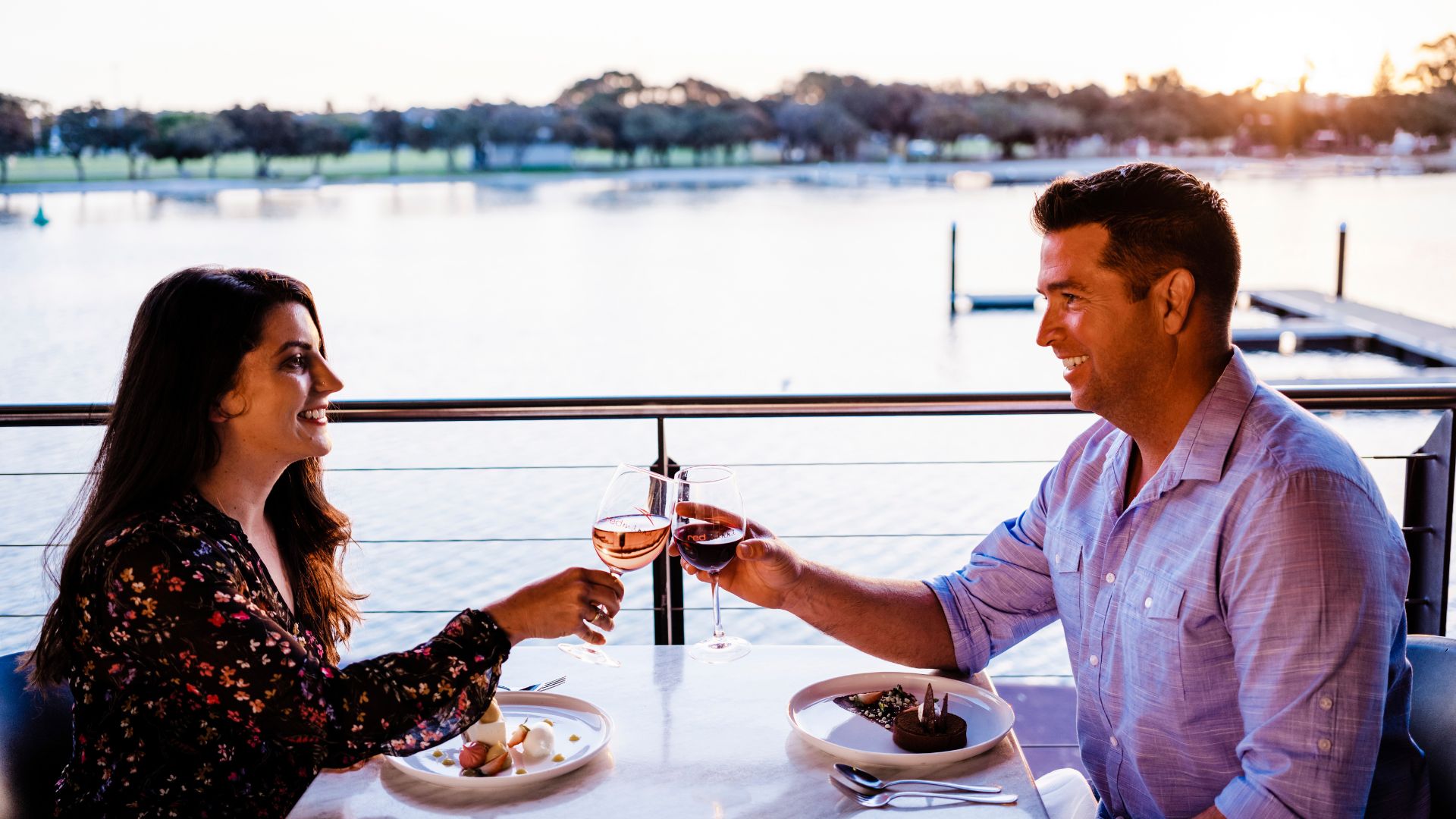 a couple toasting wine in front of the Mandurah Estuary