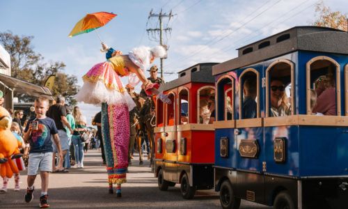 a fairy on stilts and a children's train