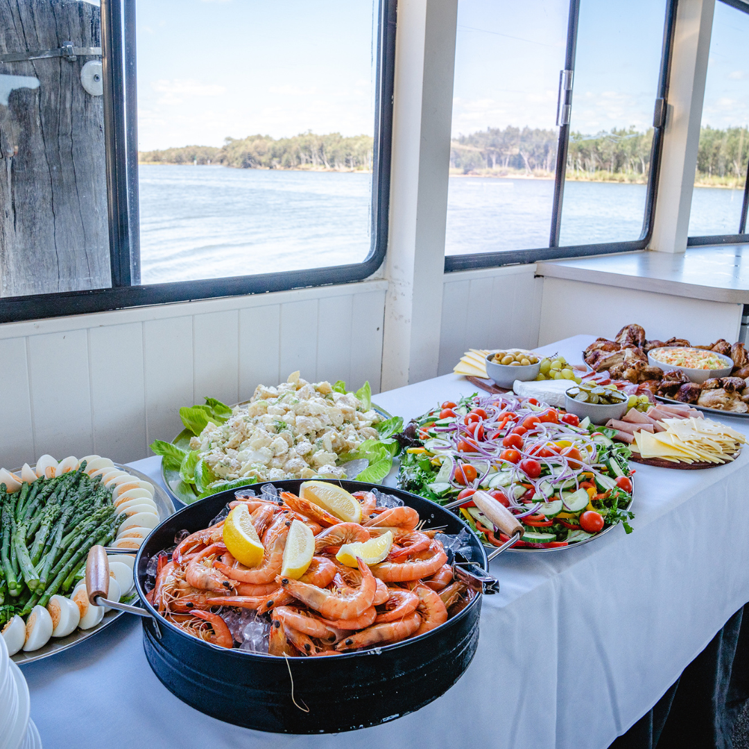 a buffet of food on a boat with a view of the Murray River