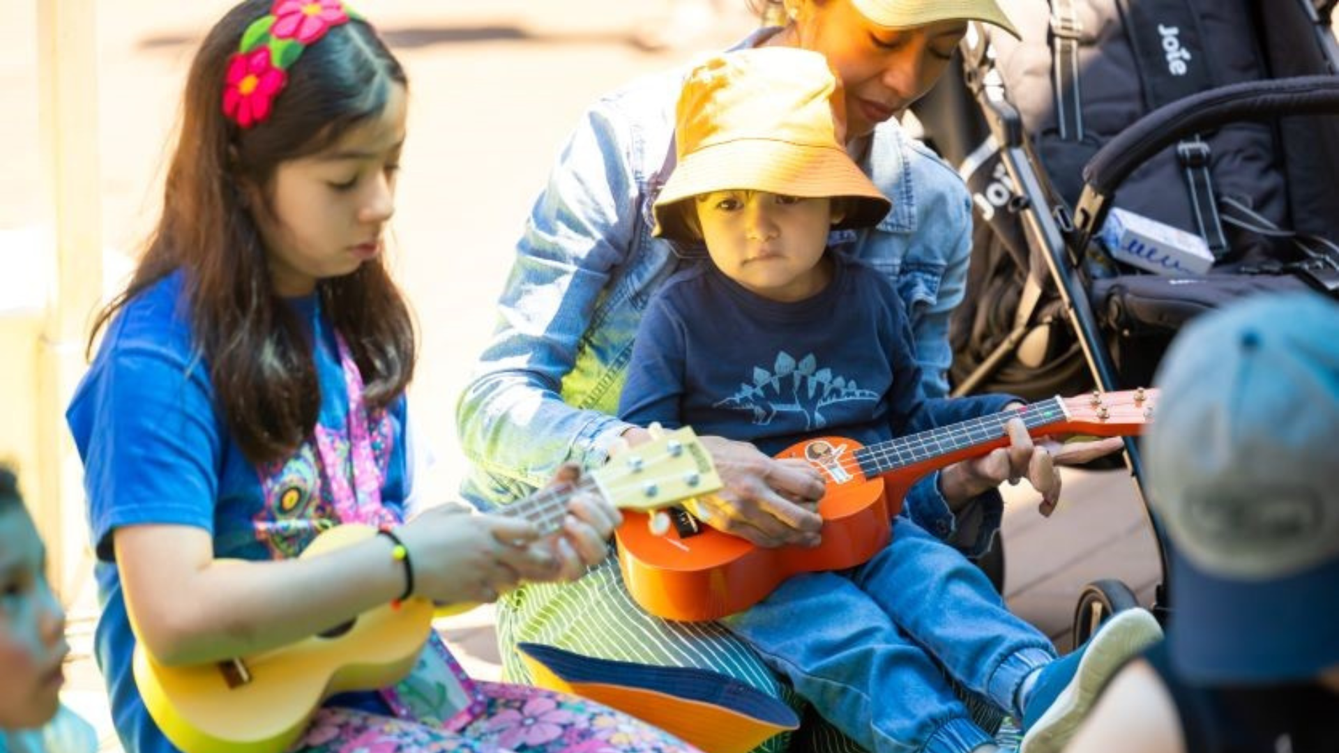 a group of children playing ukulele in a park