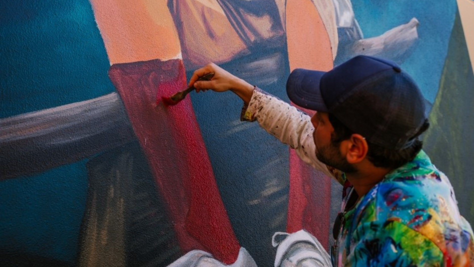 Artist in action painting a mural