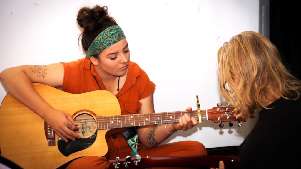 a young woman playing the guitar