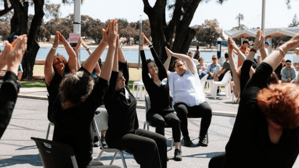 a group of people sitting in chairs with their hands up in the air