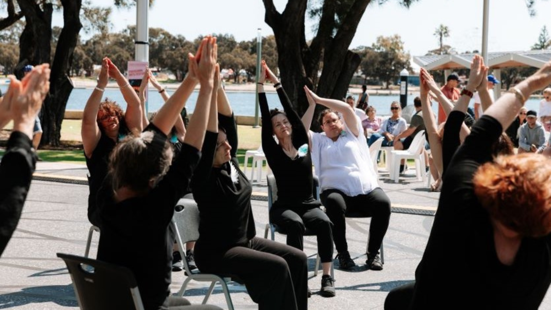 a group of people sitting in chairs with their hands up in the air