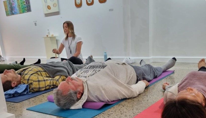 a group of people doing yoga in a room