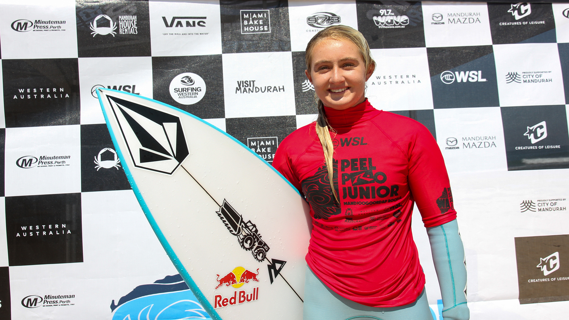 a young woman in a red shirt holding a surfboard