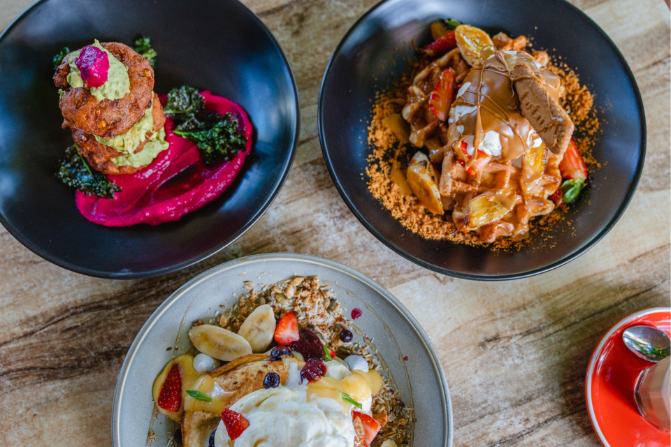 three plates of food sitting on a wooden table