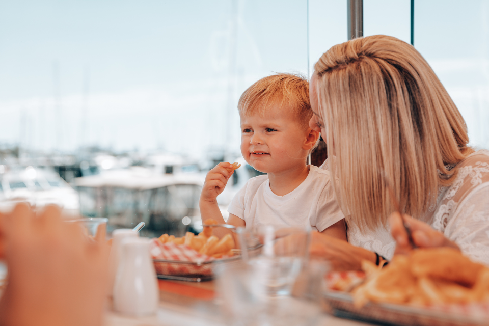 A woman and her young son eating fish & chips at a restaurant