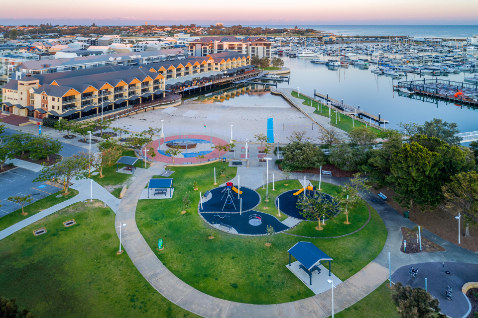 an aerial view of a park with a marina in the background