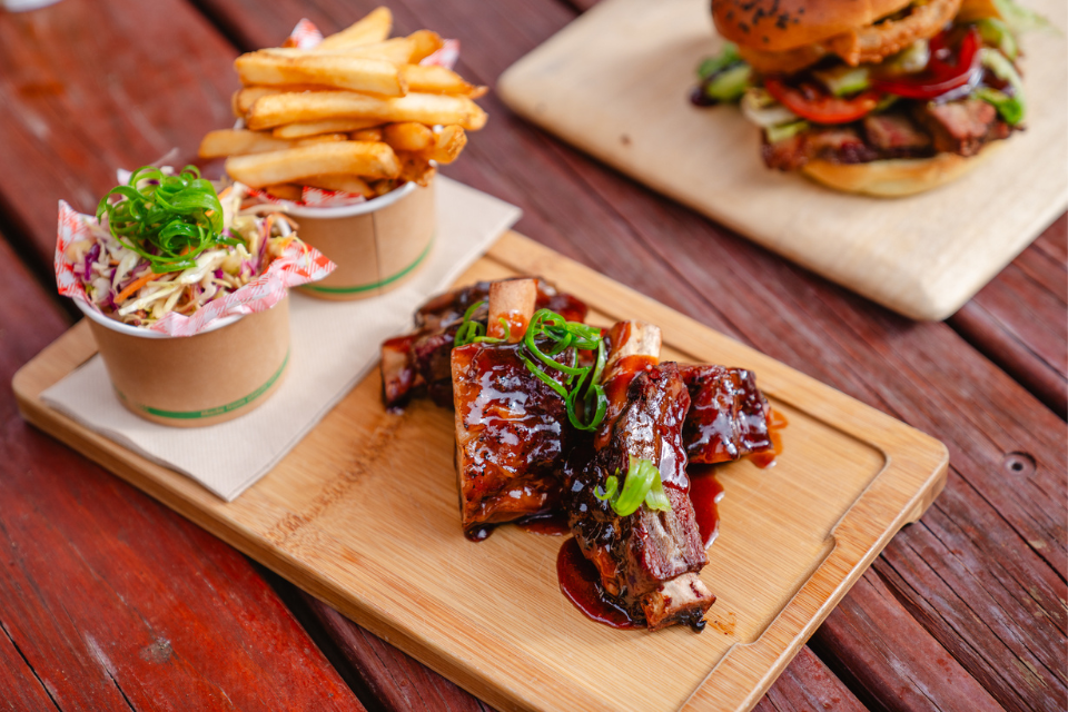 a wooden cutting board topped with a burger and fries